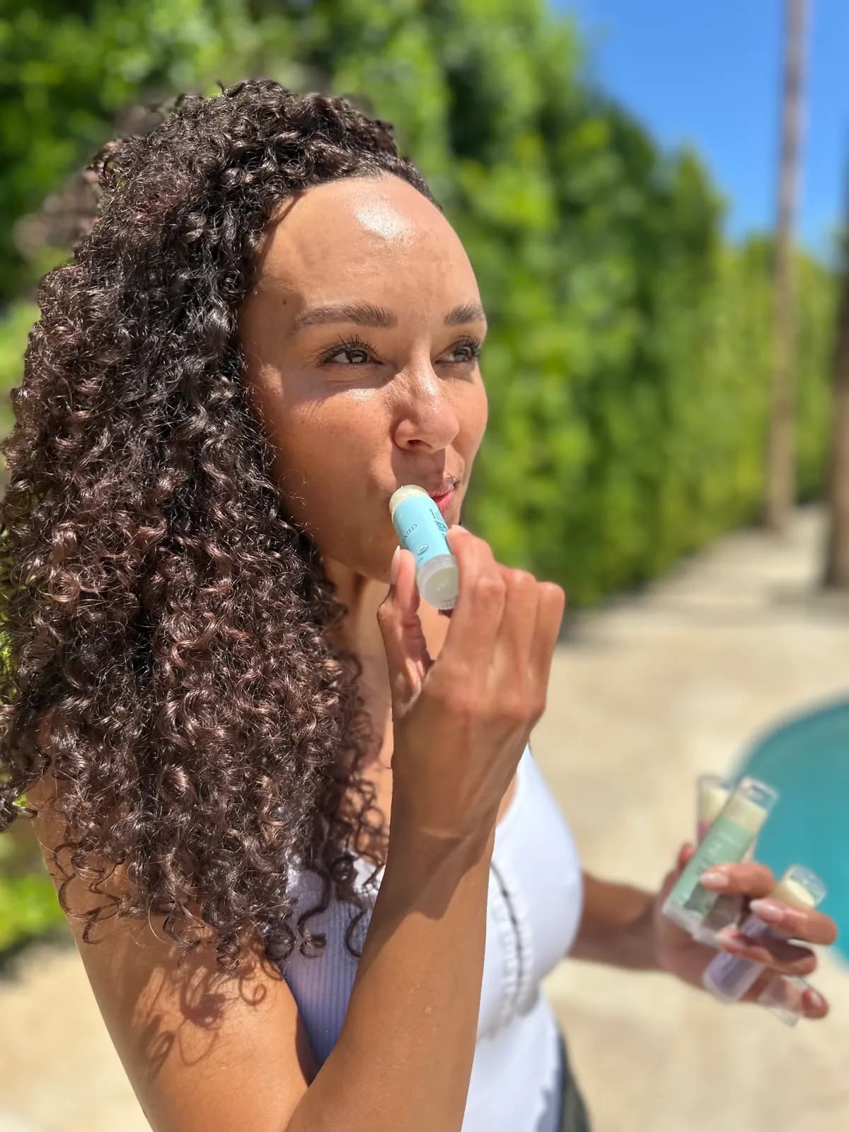 Founder applying Numbrrrz lip balm with a smile