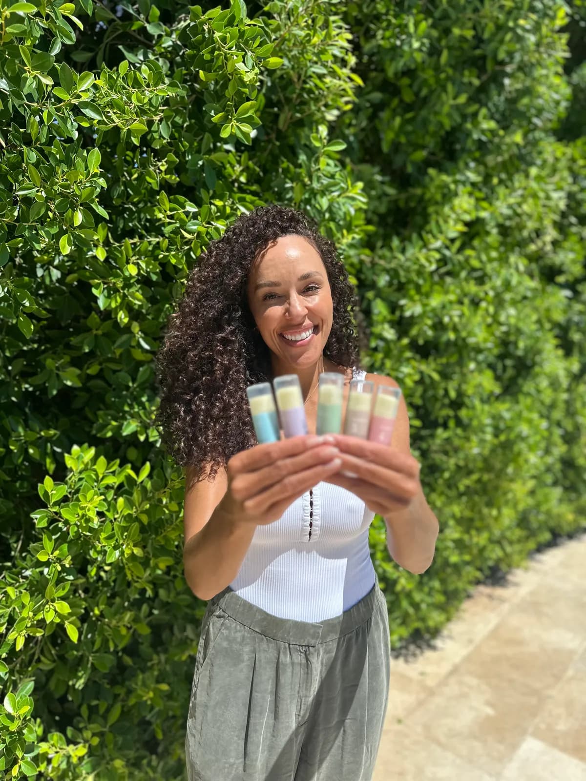 Numbrrrz lip balm collection displayed in a garden setting