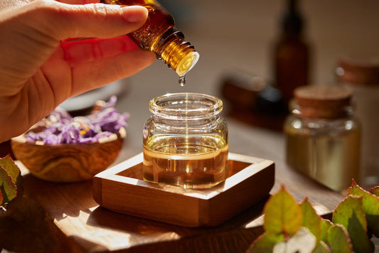 dropping organic essential oil in glass jar